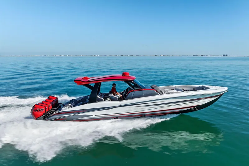  Yacht Photos Pics 2024 MTI V42 speedboat cruising on clear blue water, featuring powerful engines.