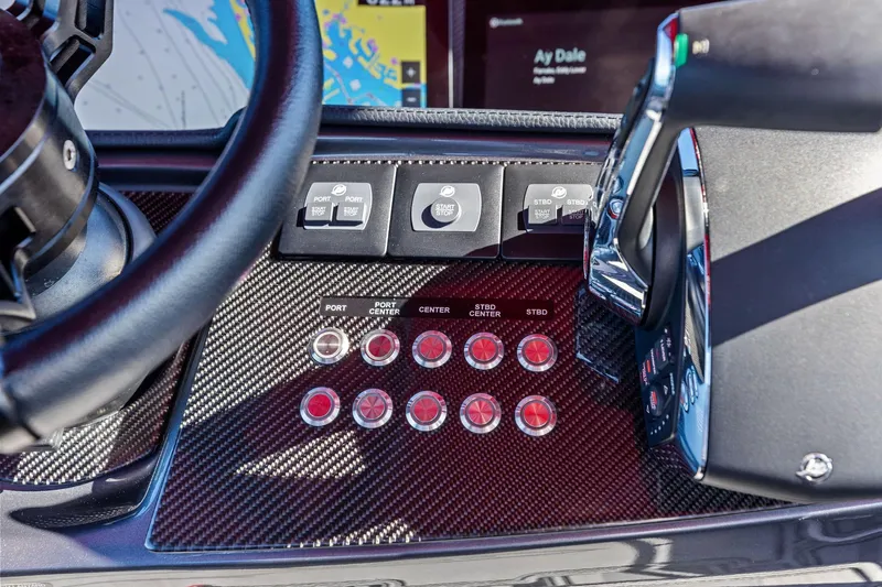  Yacht Photos Pics Control panel of 2024 MTI V42 boat with carbon fiber finish and navigation controls.
