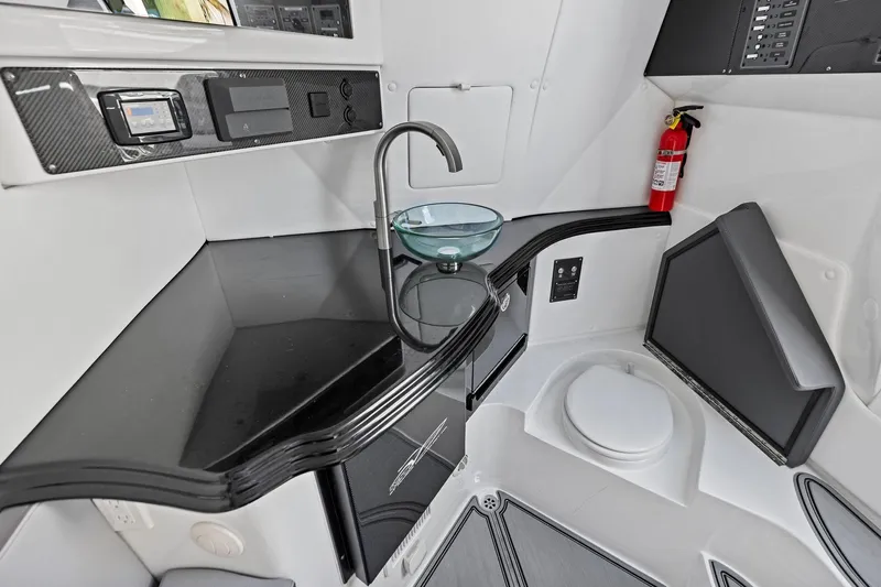  Yacht Photos Pics Modern MTI V42 boat interior with sleek black countertop, glass sink, and fire extinguisher.