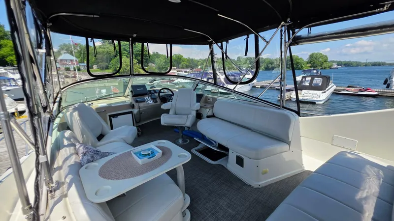  Yacht Photos Pics 2005 Carver 36 Mariner yacht interior with seating, table, and helm, docked by a scenic lake.