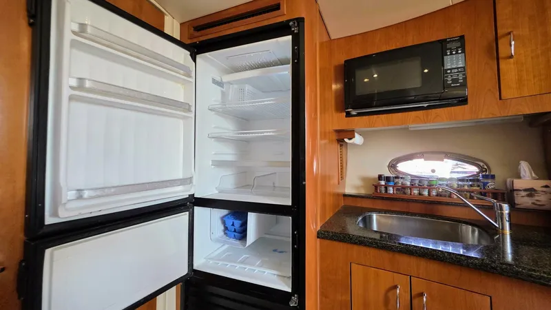  Yacht Photos Pics 2005 Carver 36 Mariner kitchen with open fridge, microwave, and sink.