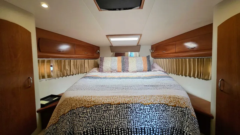  Yacht Photos Pics Cozy bedroom in 2005 Carver 36 Mariner yacht with patterned bedding and wooden cabinets.