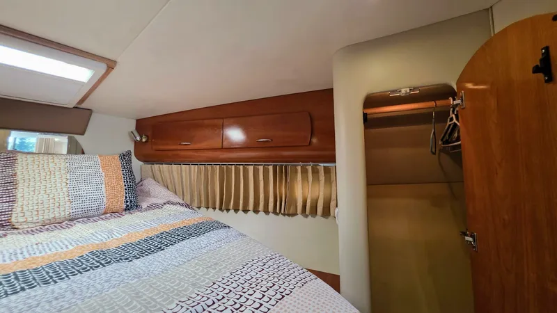  Yacht Photos Pics Interior of 2005 Carver 36 Mariner with bed, wooden cabinets, and open closet.