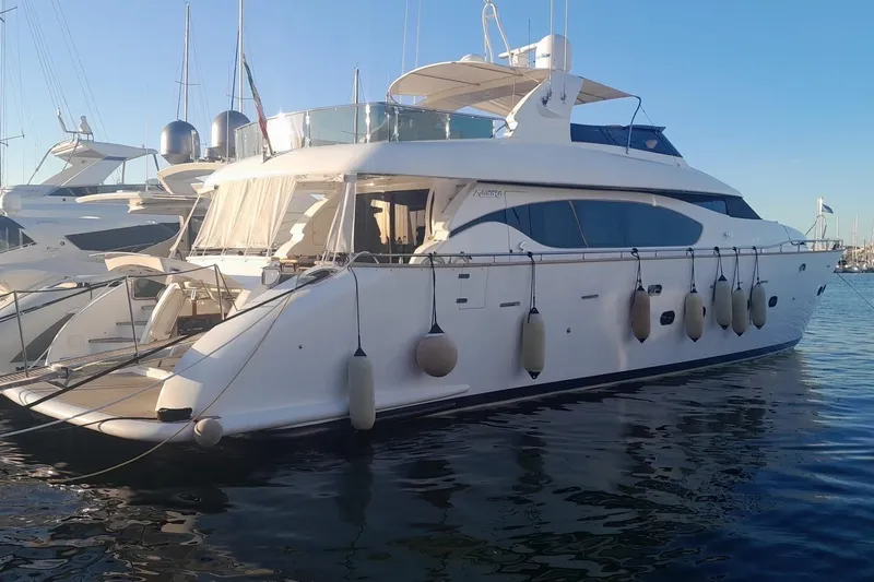  Yacht Photos Pics Luxurious 2004 Maiora 24 S yacht docked in a serene marina setting.