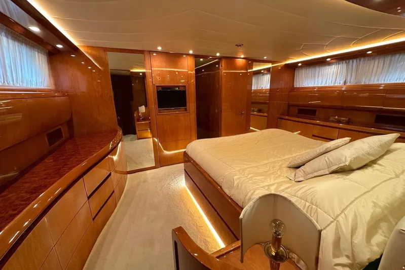  Yacht Photos Pics Luxurious bedroom interior of 2004 Maiora 24 S yacht with elegant wood finishes.