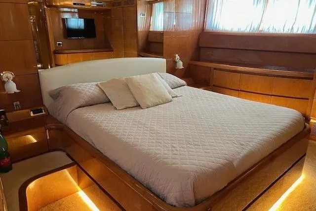  Yacht Photos Pics Luxurious bedroom interior of 2004 Maiora 24 S yacht with elegant wood finishes.