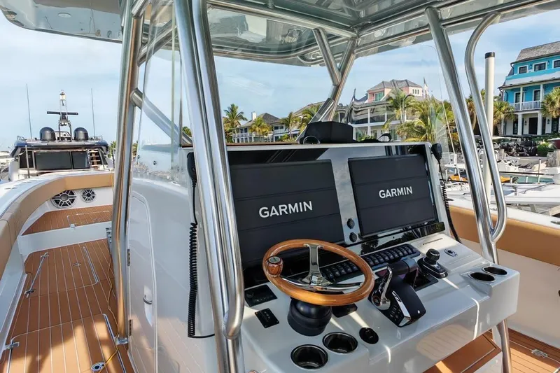  Yacht Photos Pics Freeman 42 boat cockpit with Garmin displays, wooden steering wheel, and marina view, 2025 model.