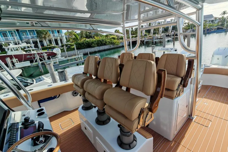  Yacht Photos Pics Luxurious seating on a 2025 Freeman 42 boat, docked near waterfront homes.