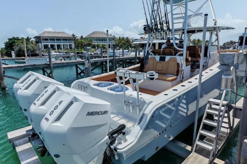  Yacht Photos Pics 2025 Freeman 42 boat docked, featuring Mercury engines, in a marina with waterfront homes.