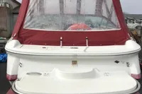 2003 Cobalt 200 boat with red canopy and visible propeller, docked on a cloudy day.