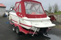 2003 Cobalt 200 boat with red canopy on a trailer, parked outdoors.