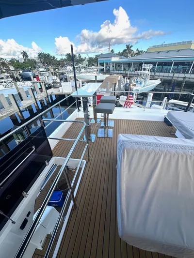 American Dream Yacht Photos Pics Luxurious 2023 Schaefer 660 yacht deck with marina view, featuring modern seating and sleek design.