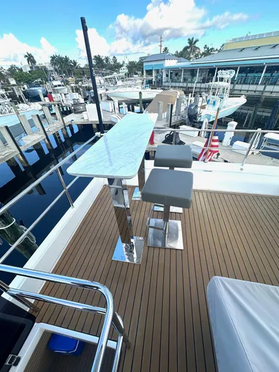 American Dream Yacht Photos Pics Schaefer 660 yacht deck with modern bar stools and marina view, 2023 model.