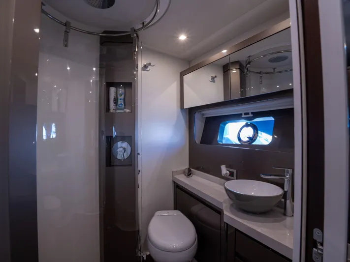 American Dream Yacht Photos Pics Luxurious bathroom in 2023 Schaefer 660 yacht with modern fixtures and porthole window.
