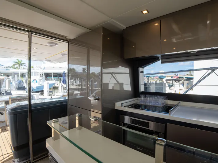 American Dream Yacht Photos Pics Modern kitchen interior on 2023 Schaefer 660 yacht, featuring sleek cabinetry and outdoor view.