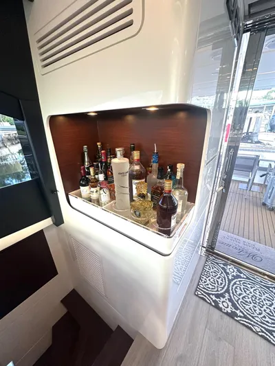 American Dream Yacht Photos Pics Bar area inside a 2023 Schaefer 660 yacht, featuring various liquor bottles.