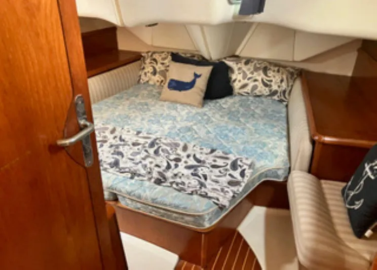 Weagle Yacht Photos Pics Cozy cabin interior of 2002 Jeanneau 43DS sailboat with nautical-themed bedding.