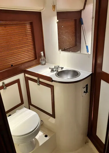 Weagle Yacht Photos Pics 2002 Jeanneau 43DS yacht bathroom with sink, toilet, and wooden accents.