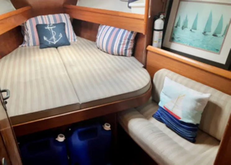 Weagle Yacht Photos Pics Cozy cabin interior of 2002 Jeanneau 43DS sailboat with nautical decor and striped cushions.