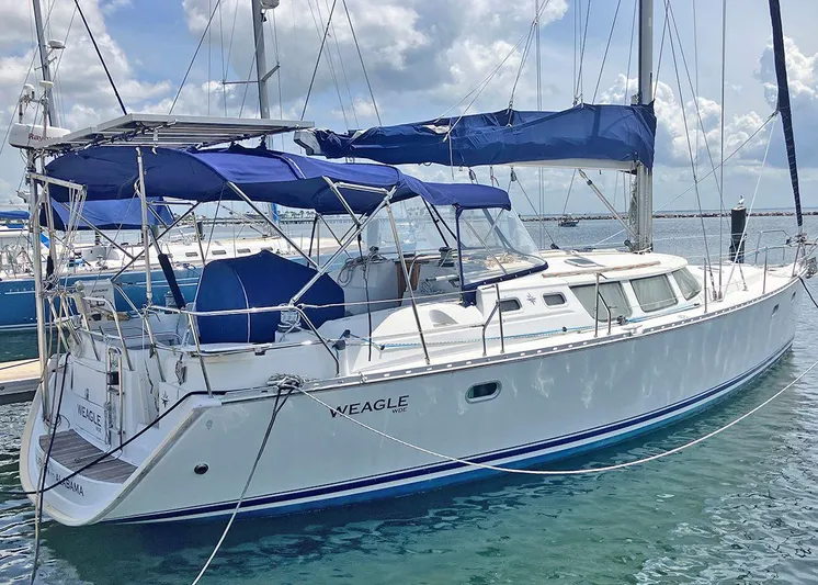 Weagle Yacht Photos Pics 2002 Jeanneau 43DS sailboat docked, featuring blue canopy and sleek white hull.