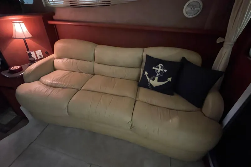 Northern Comfort Yacht Photos Pics Beige leather sofa with nautical-themed pillows in a 2005 Silverton 34 Convertible yacht interior.