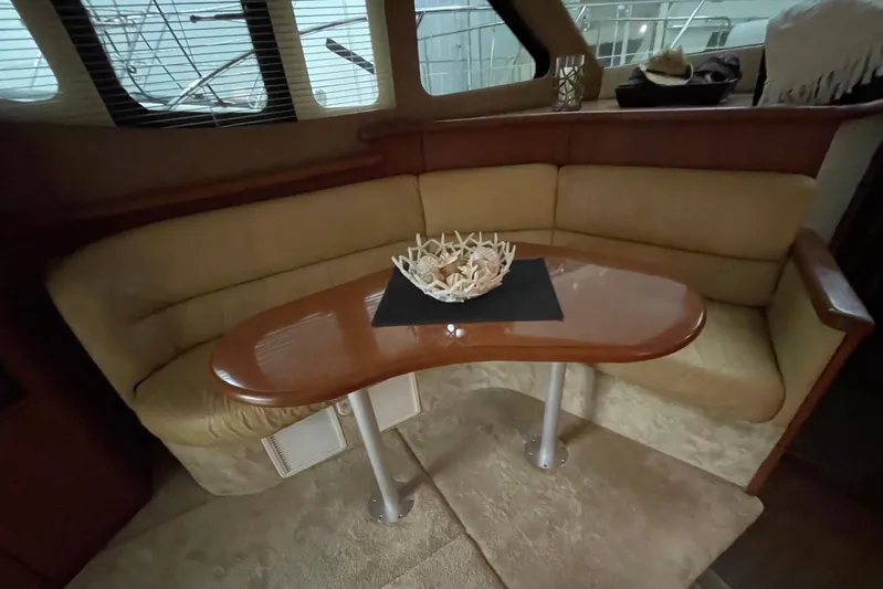 Northern Comfort Yacht Photos Pics Interior of 2005 Silverton 34 Convertible yacht with cozy seating and wooden table.