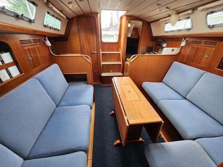 Ceres Yacht Photos Pics Interior of 2016 Hallberg-Rassy 342 yacht with blue seating and wooden finishes.