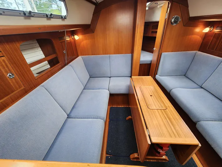 Ceres Yacht Photos Pics 2016 Hallberg-Rassy 342 yacht interior with blue seating and wooden table.
