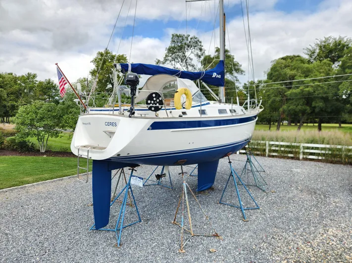 Ceres Yacht Photos Pics 2016 Hallberg-Rassy 342 sailboat on stands, outdoors, with trees and cloudy sky.