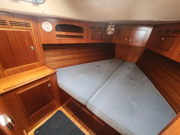 Ceres Yacht Photos Pics Cozy cabin interior of 2016 Hallberg-Rassy 342 sailboat with wooden finish and blue cushions.