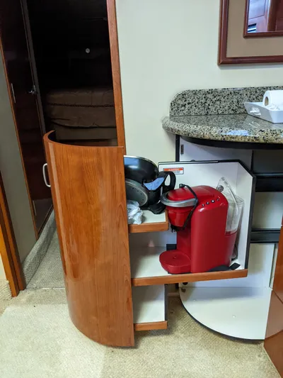  Yacht Photos Pics Wooden cabinet with a coffee maker and kitchenware inside a 2006 Sea Ray 44 Sundancer yacht.