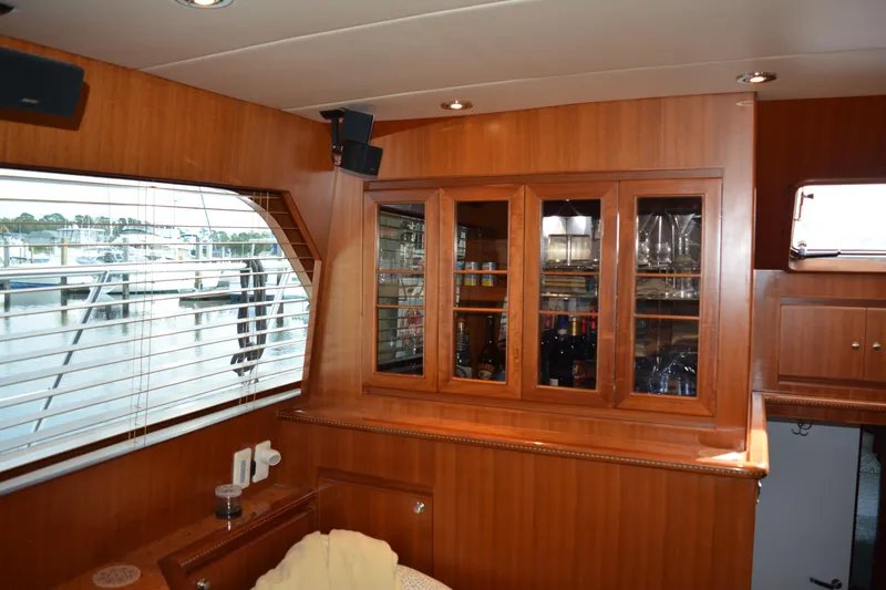 Wandra Yacht Photos Pics Luxurious interior of 2008 Novatec Islander 60 yacht with wooden cabinetry and glassware display.