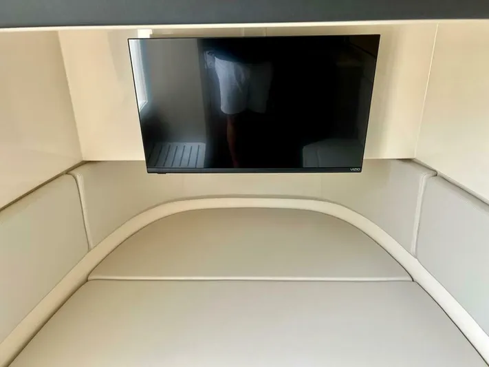  Yacht Photos Pics 2023 Scout 377 LXF cabin interior with mounted TV and cushioned seating.