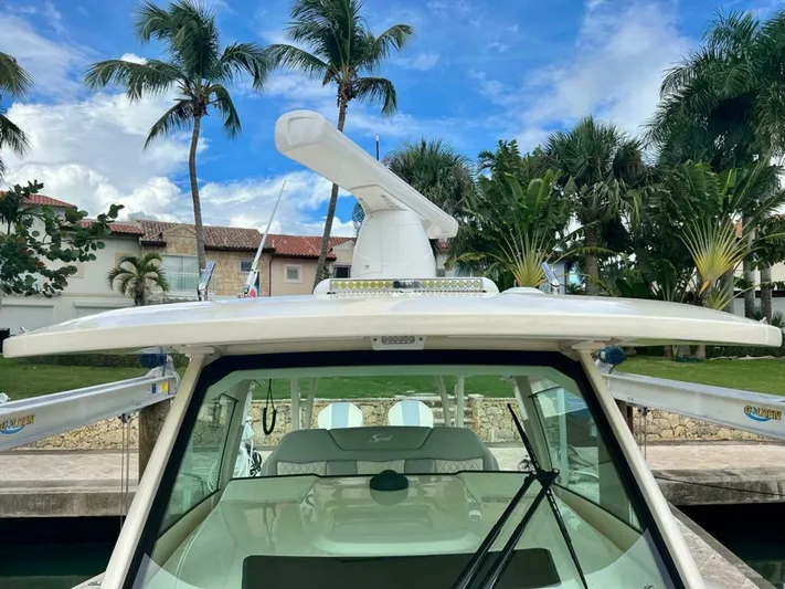 Yacht Photos Pics 2023 Scout 377 LXF boat docked, featuring radar equipment, with palm trees in the background.