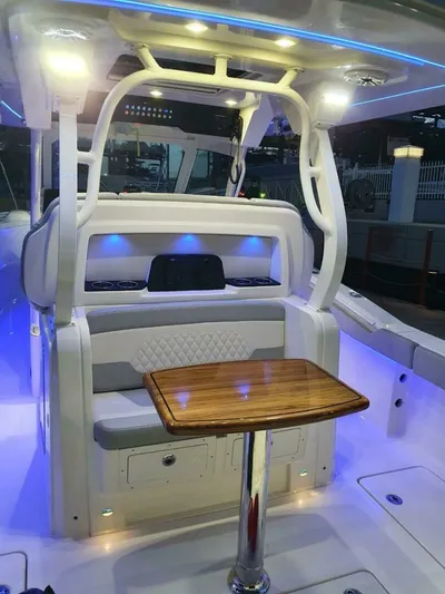  Yacht Photos Pics 2023 Scout 377 LXF boat interior with illuminated seating and wooden table.