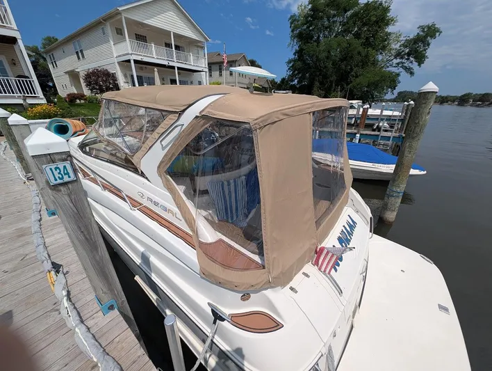 No Drama Yacht Photos Pics 2002 Regal Commodore 3860 docked by waterfront homes, featuring a beige canopy.