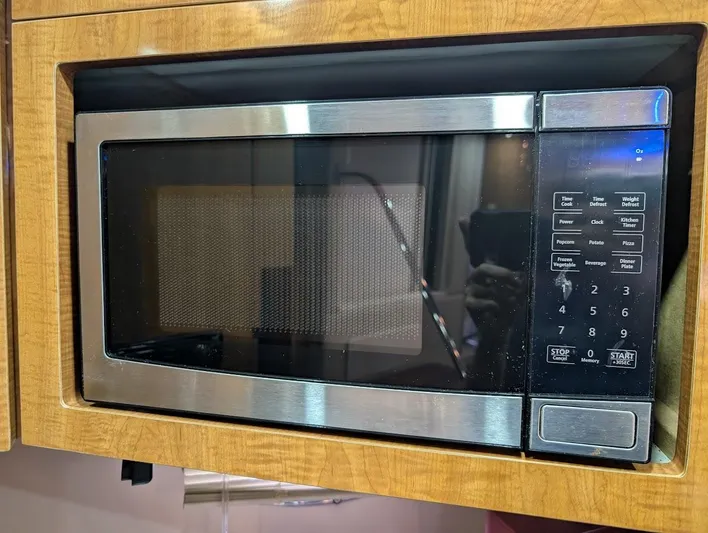 No Drama Yacht Photos Pics Built-in microwave oven with digital controls in a wooden cabinet.