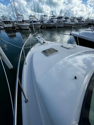  Yacht Photos Pics 2021 Grady-White Express 370 docked among other boats under a cloudy sky.