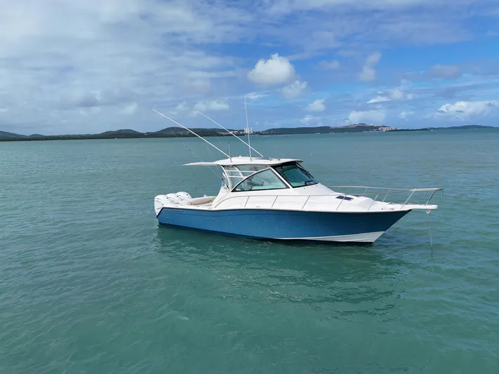  Yacht Photos Pics 2021 Grady-White Express 370 boat on calm blue water under a partly cloudy sky.