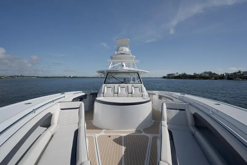  Yacht Photos Pics 2022 Yellowfin 54 Offshore boat on calm water, showcasing spacious deck and seating.