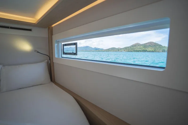 Blossom Yacht Photos Pics Luxurious interior of 2024 Lagoon 46 yacht with scenic ocean view through window.