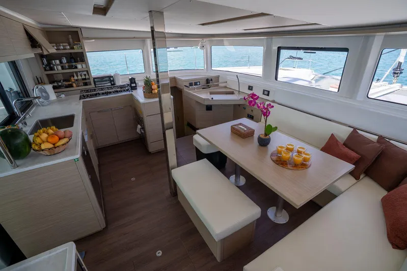 Blossom Yacht Photos Pics Luxurious interior of 2024 Lagoon 46 catamaran with modern kitchen and dining area.