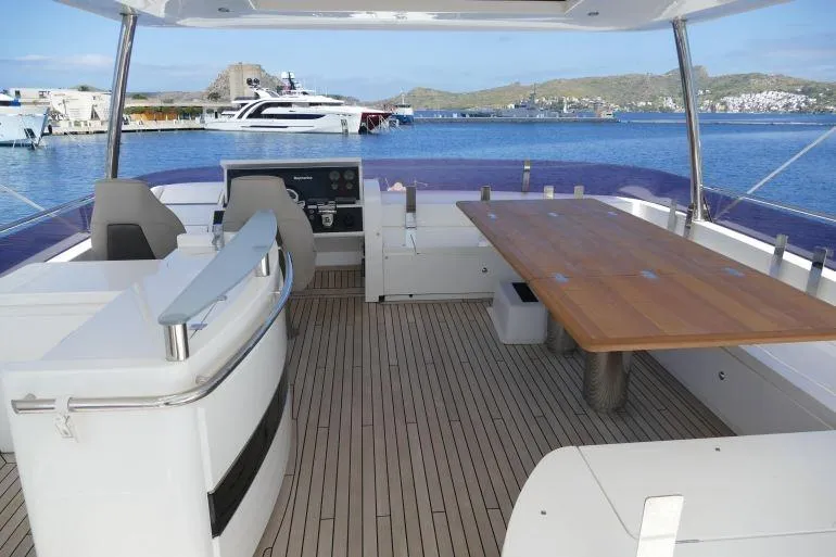  Yacht Photos Pics Flybridge deck of 2016 Princess 72 Motor Yacht with seating and table, overlooking marina.