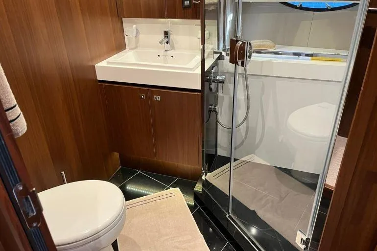  Yacht Photos Pics Luxurious bathroom in 2016 Princess 72 Flybridge Motor Yacht with modern fixtures and wood accents.