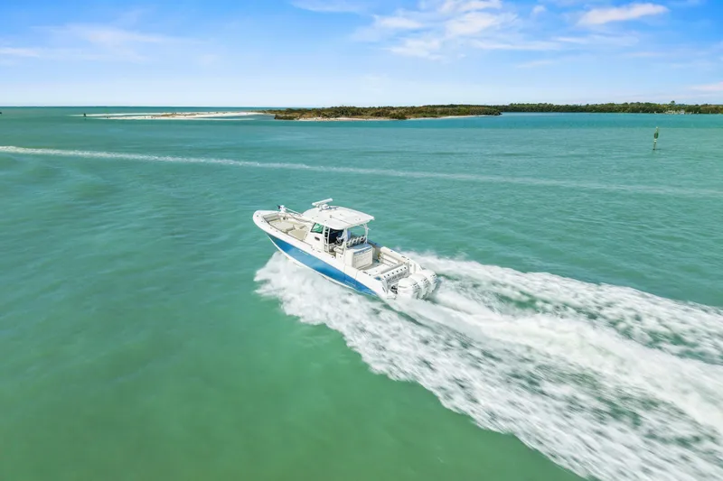  Yacht Photos Pics 2017 Boston Whaler 350 Outrage cruising on turquoise waters under a clear blue sky.