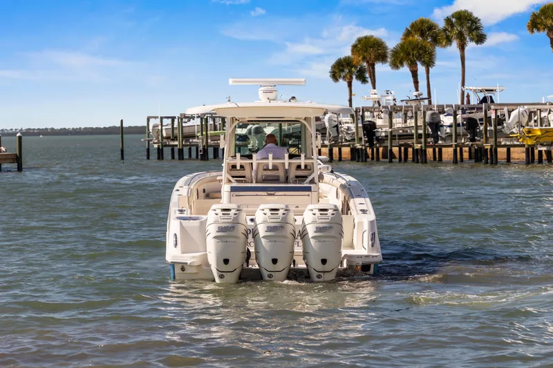  Yacht Photos Pics 2017 Boston Whaler 350 Outrage boat with triple engines on water near dock.