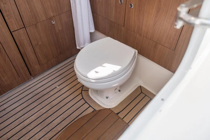  Yacht Photos Pics 2017 Boston Whaler 350 Outrage boat bathroom with wooden cabinetry and flooring.