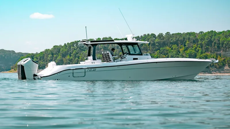  Yacht Photos Pics 2024 HCB 42 Lujo boat on calm water with forested shoreline in background.