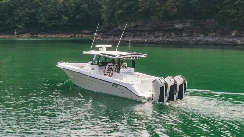  Yacht Photos Pics 2024 HCB 42 Lujo boat cruising on a serene green lake with lush forest backdrop.