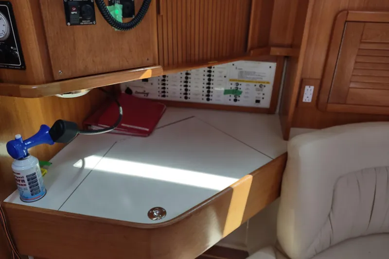 Spotted Drum II Yacht Photos Pics Navigation station in a 2004 Catalina 42 Mk II sailboat, featuring control panel and seating.